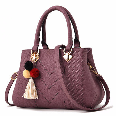 Embossed top handle handbag with pompom